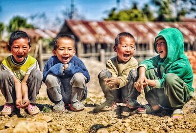 Group of children sitting outdoors and laughing 