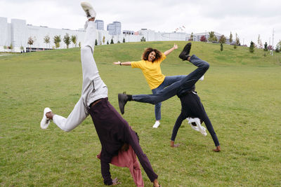 Carefree young men doing cartwheel by friend in park