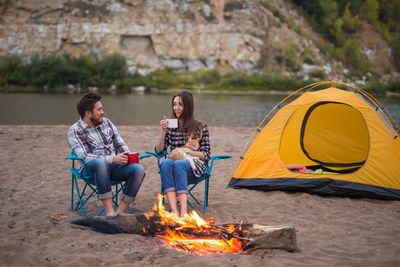 People sitting by bonfire