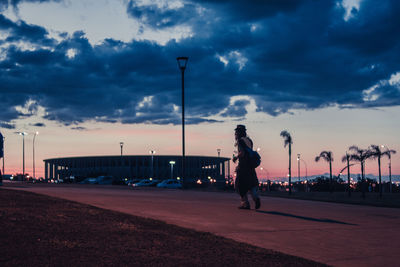 Full length of man on street against sky during sunset