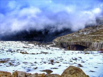 Snow covered mountain against cloudy sky