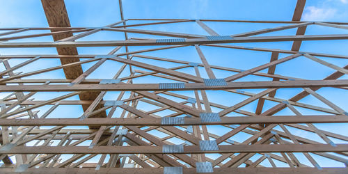 Low angle view of metallic structure against blue sky