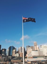 Low angle view of flag against blue sky