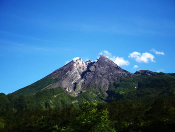 Low angle view of mountain against blue sky