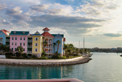 Buildings by ocean against sky