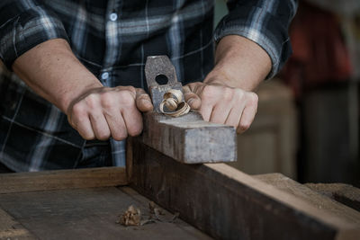 Midsection of man working on wood