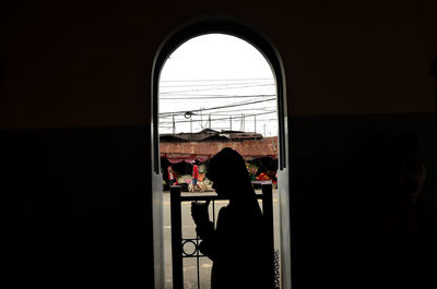 Silhouette people sitting in front of window