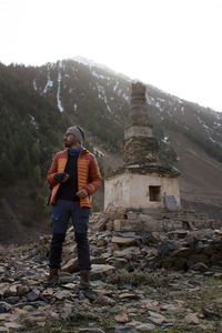 Rear view of man standing on snow covered mountain