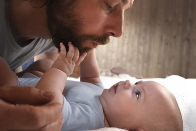 Father with his daughter, tiny infant. newborn baby smiling, laughing and looking up at him. daddy