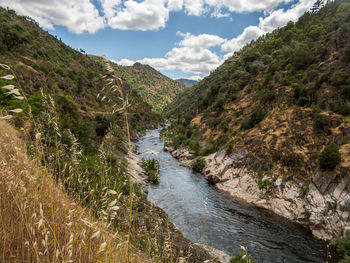 Scenic view of river amidst mountains against sky