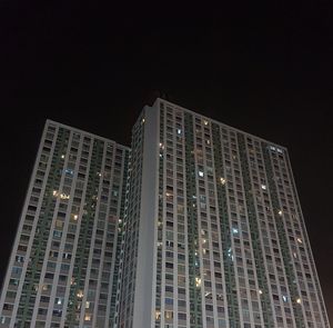 Low angle view of illuminated buildings against clear sky at night