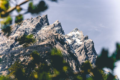 Close-up of snow on rock against sky