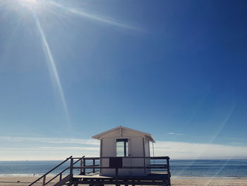Built structure on beach against blue sky