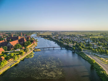 High angle view of river amidst buildings in city against clear sky