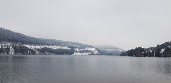 Scenic view of lake by mountains against sky