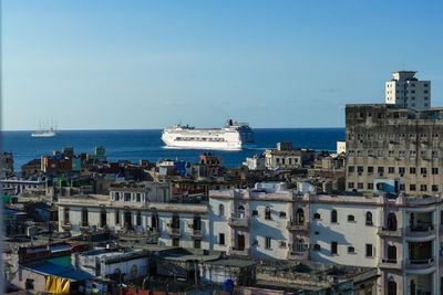 High angle view of buildings by sea against clear sky