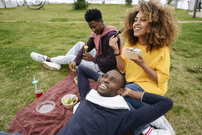 Woman eating lunch with friends in park at picnic