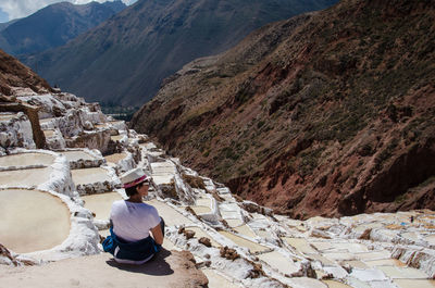 Rear view of woman sitting on salt basin at moray