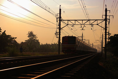 Railroad tracks against sky during sunset