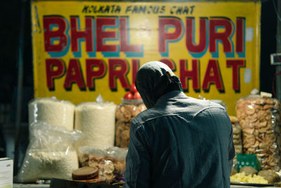 Rear view of man working at store