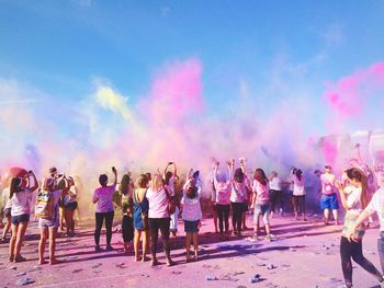 People celebrating holi festival outdoors against sky