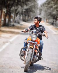 Man riding motorcycle on road in city