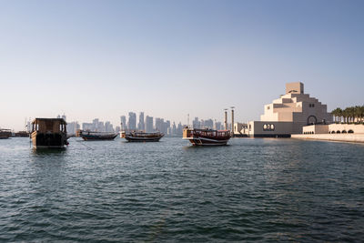 Sailboats in sea against clear sky