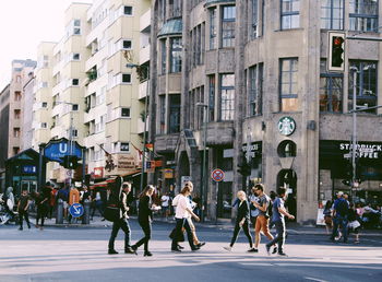 People on street against buildings in city