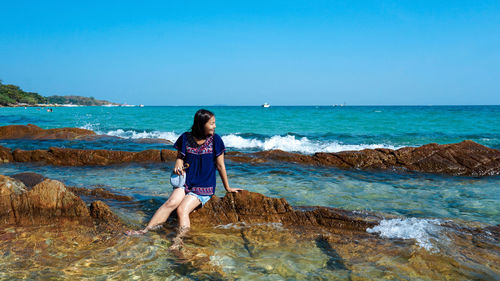 Woman on beach against clear blue sky