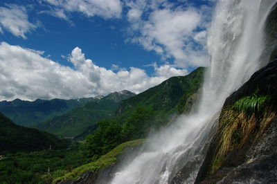 Scenic view of waterfall against sky