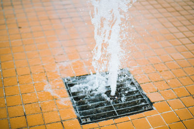 High angle view of water splashing from drain