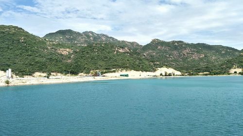 Scenic view of sea and mountains against sky