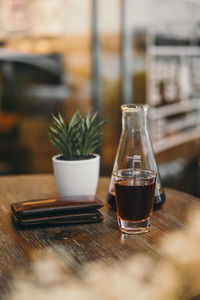 Black coffee and potted plant on table