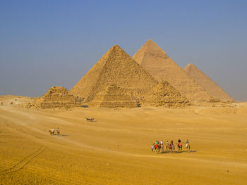 Group of people on desert against sky