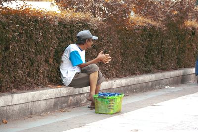 Side view of a man sitting on plants