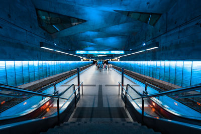 People walking in illuminated tunnel