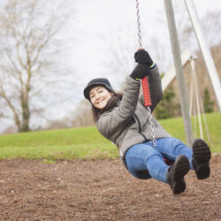 Portrait of smiling man on swing in playground