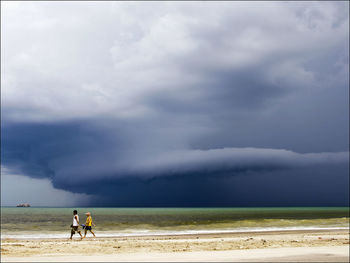 People on beach against sky