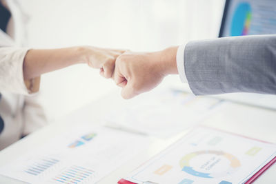 Close-up of business people bumping fist at office