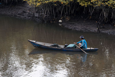 Side view of man boating on lake