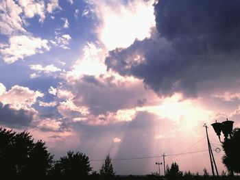 Silhouette of electricity pylon against cloudy sky