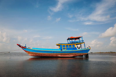 Fishing boat on sea against sky