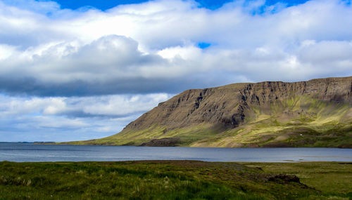 Scenic view of land and mountains against sky