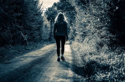 Rear view of woman walking on footpath