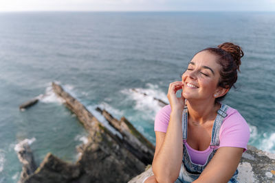 Portrait of young woman looking at sea