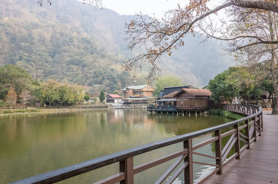 Scenic view of lake by buildings against mountain