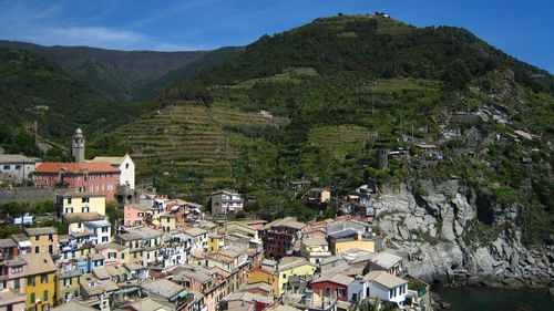 Aerial view of townscape by mountain against sky