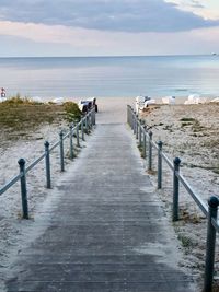 Wooden posts on beach against sky