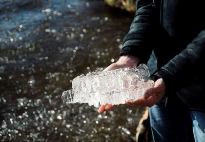 Midsection of man holding ice at beach