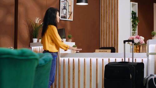 Rear view of woman sitting on table at home